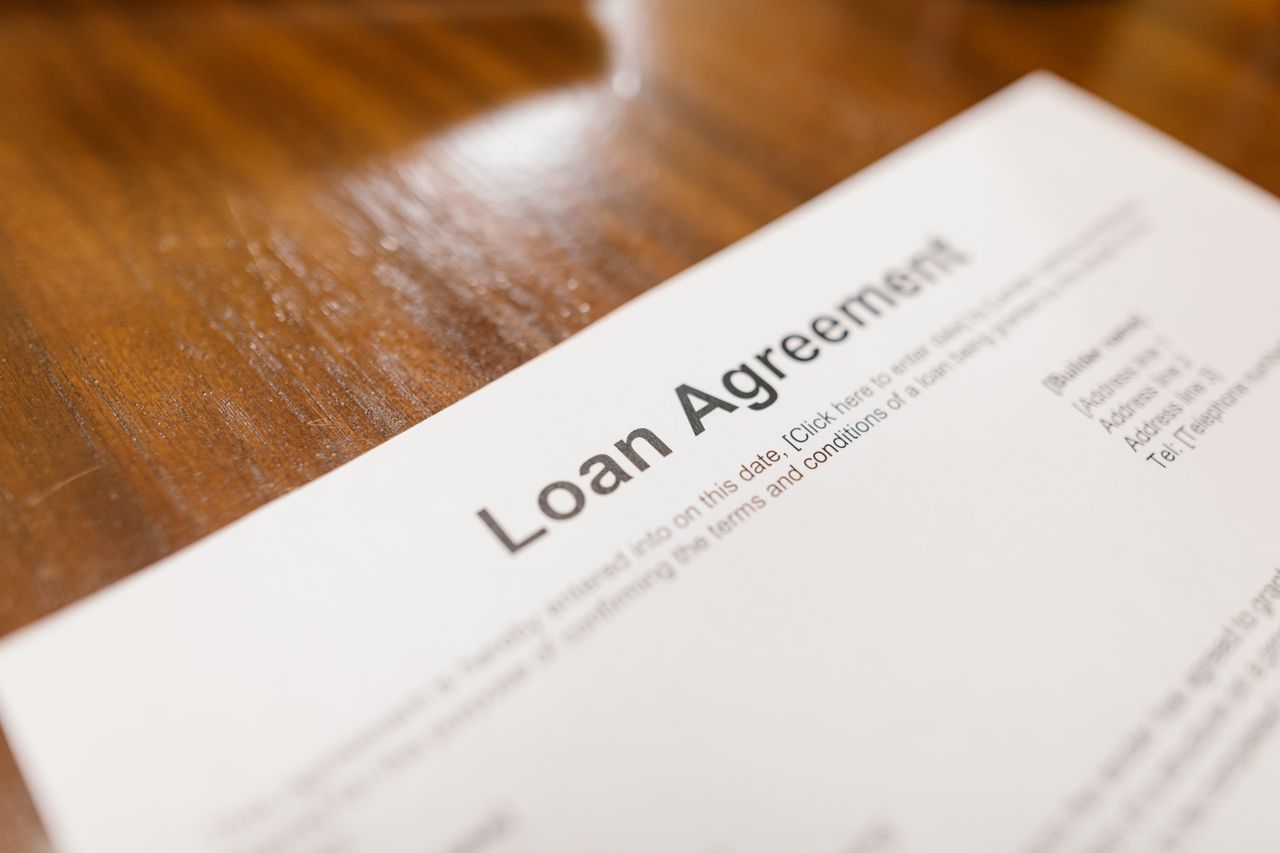 Mastering the First Impression: Your intriguing post title goes here Detailed loan agreement document close-up on a wooden table representing legal and financial concepts.